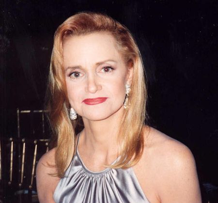 Swoosie Kurtz in a silver dress and brown hair poses for a picture.